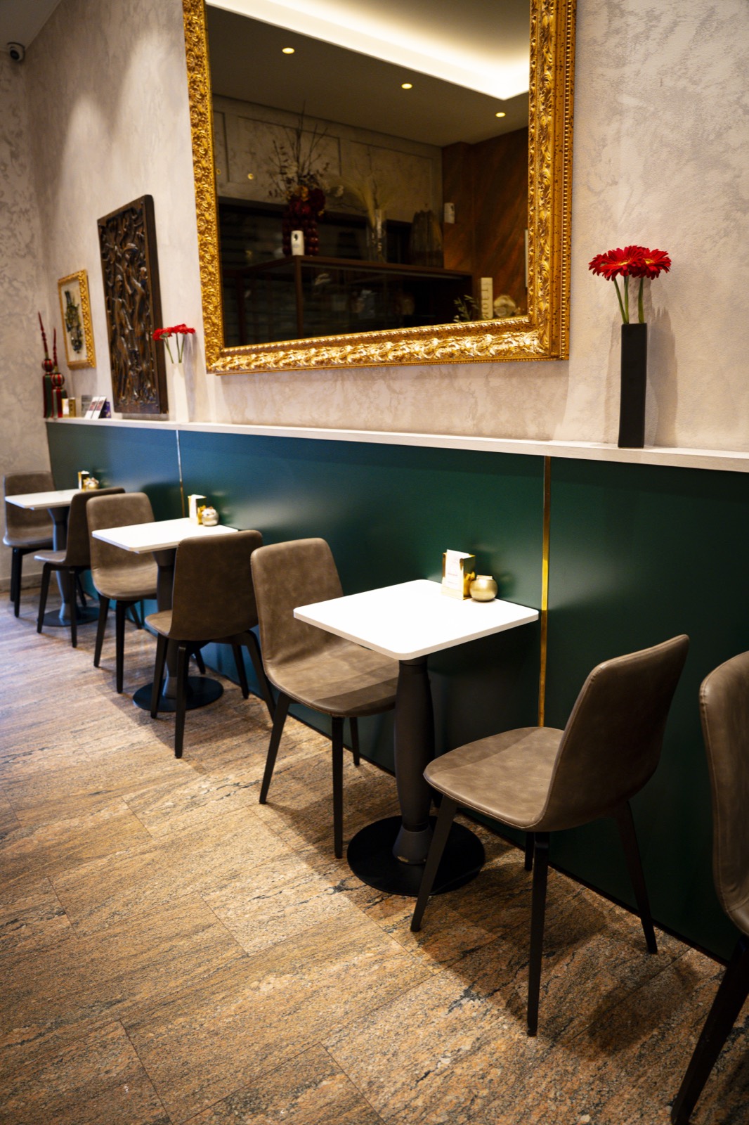 Sala di una caffetteria con sedute e boiserie verde